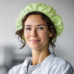 Female worker wearing a light green PLA/PBAT disposable bouffant hair cap