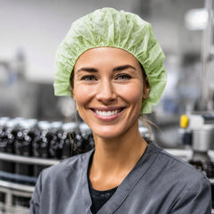 Food-processing worker wearing a disposable PLA/PBAT bouffant cap