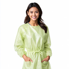 Person wearing a green PLA/PBAT disposable gown on white background