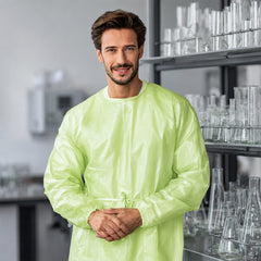 Person wearing green PLA/PBAT gown in a clean work area
