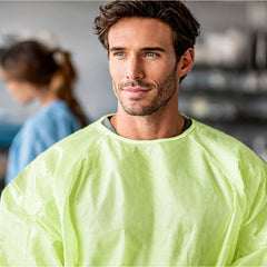 Person wearing green disposable gown in a manufacturing support setting