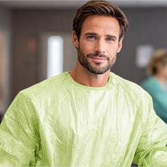 Person wearing green PLA/PBAT gown in an indoor work area