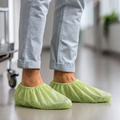 Green PLA/PBAT shoe covers in a controlled indoor workspace
