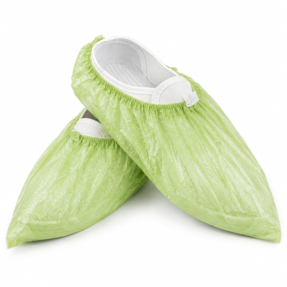 Crossed pair of green microporous shoe covers on white